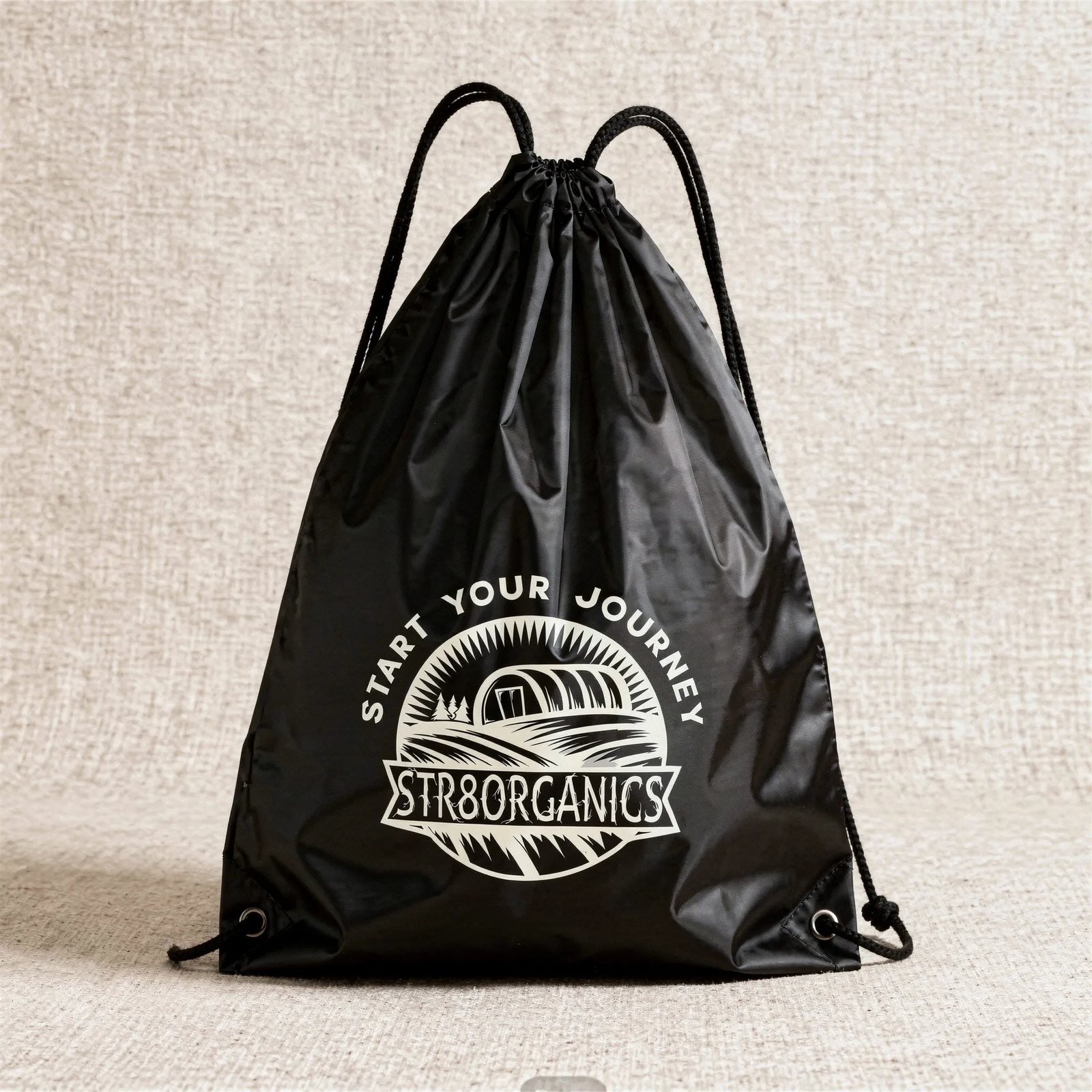 Black drawstring cinch bag printed with the STR8ORGANICS roundel and the words start your journey arced above it.